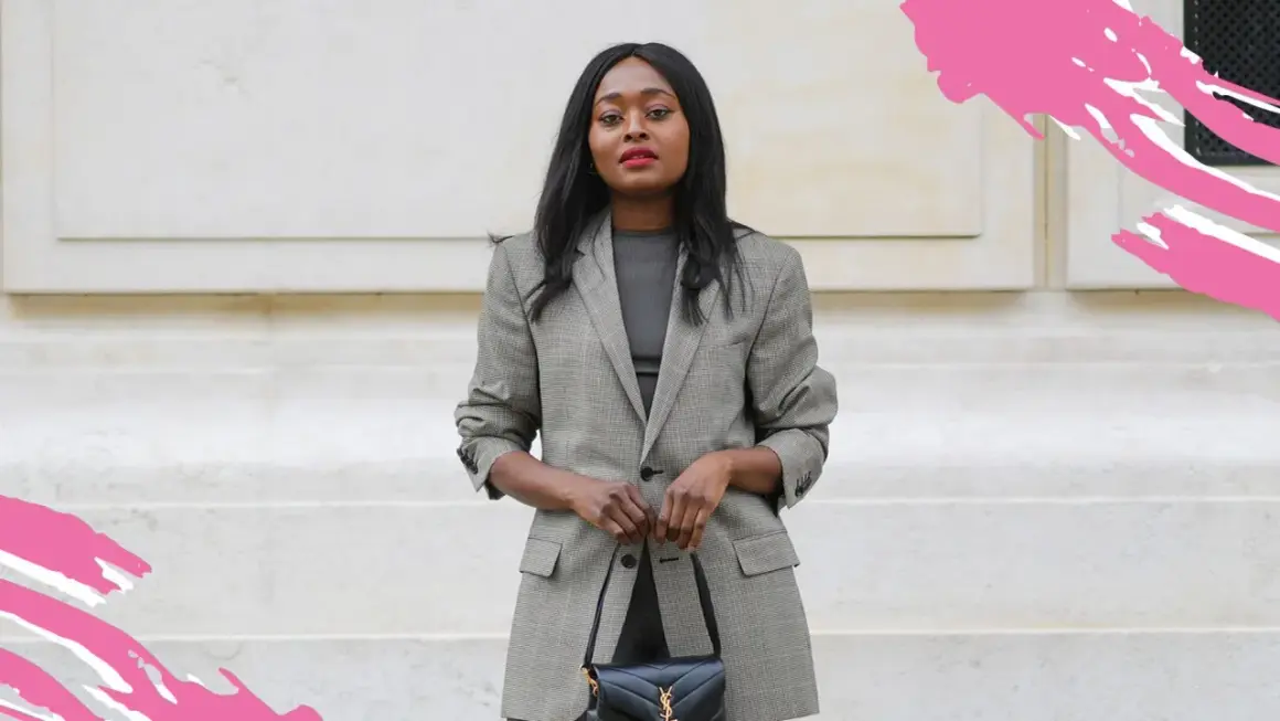 Eine Frau im karierten Blazer und schwarzer Tasche zeigt, was ist business casual: schick und doch entspannt.