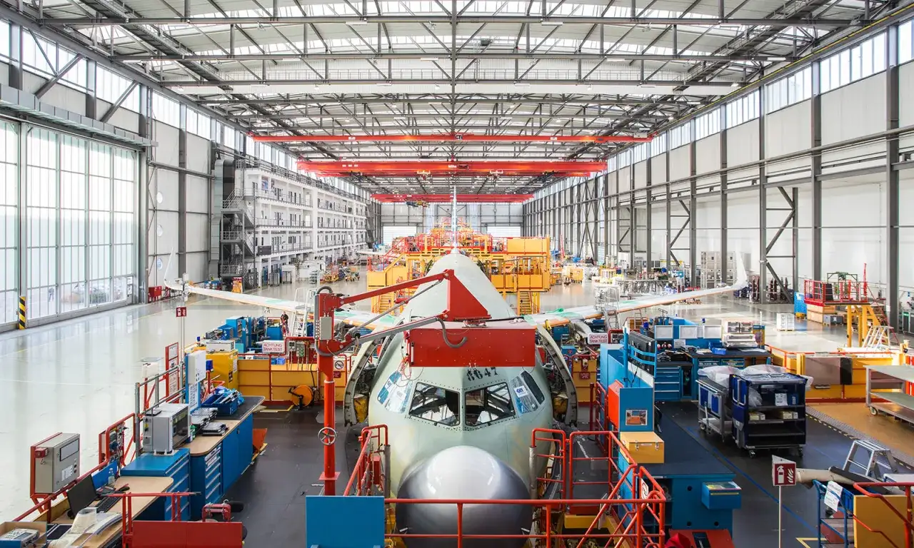 Große Flugzeughalle mit einem Airbus-Rumpf im Bau. Hier wird der Airbus-Tarifvertrag umgesetzt, der die Arbeitsbedingungen regelt.